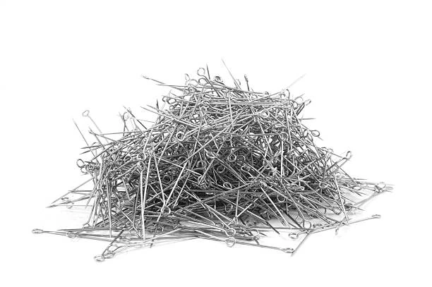 A heap of sewing needles on a white background, with nothing else in the pile.